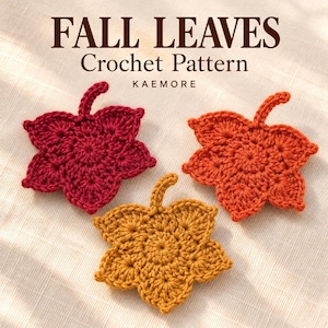 Op de afbeelding: Drie gehaakte bladmotieven in donkerrood, feloranje en goudgeel, elk met een centrale steel. De tekst "FALL LEAVES Crochet Pattern KAEMORE" staat bovenaan de afbeelding in donkerbruine letters tegen een lichte achtergrond.