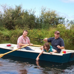 May include: Three people in a blue and white wooden rowboat on a lake. The person in the back is holding a fishing rod. The person in the middle is holding a fishing rod and the person in the front is rowing.