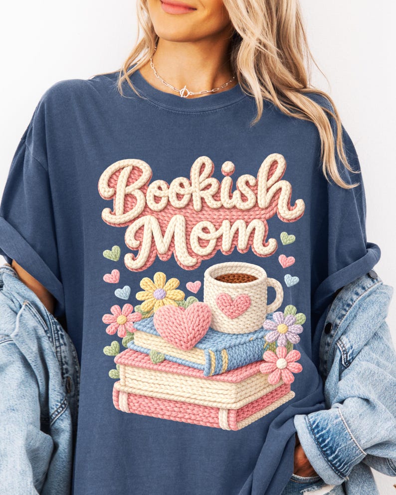 May include: Navy blue t-shirt with the text "Bookish Mom" in a knitted design. The graphic includes a stack of books, a coffee mug with a heart, flowers, and hearts.