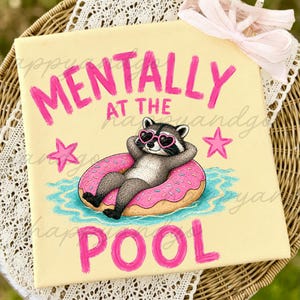 Könnte beinhalten: Hellgelber Leinwanddruck mit den pinkfarbenen Worten "MENTALLY AT THE POOL". Ein Waschbär mit herzförmiger Sonnenbrille schwimmt auf einem rosa Donut in einem Pool. Zwei rosa Sterne befinden sich auf der Leinwand.