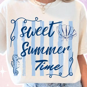 Könnte beinhalten: Cremefarbenes T-Shirt mit dem Schriftzug "Sweet Summer Time" in dunkelblauer Schrift. Das Design umfasst ein Seepferdchen, eine Muschel und blaue vertikale Streifen. Das Shirt hat kurze Ärmel und einen Rundhalsausschnitt.