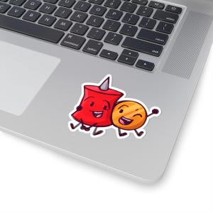 May include: A sticker featuring two cartoon characters: a red pushpin with a gray point and a smiling gold coin. The characters are hugging each other, with black outlines and white borders. The sticker is placed on a laptop.