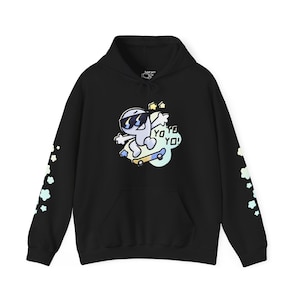 May include: Black hoodie with a cartoon character wearing sunglasses and riding a skateboard. The character is surrounded by stars and the text "YO YO YO!" is printed on the hoodie. The sleeves have a pattern of pastel colored flowers.
