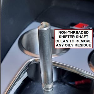 Może przedstawiać: Zbliżenie nienitowanego wału dźwigni zmiany bieg&oacute;w. Tekst na zdjęciu brzmi: "NON-THREADED SHIFTER SHAFT CLEAN TO REMOVE ANY OILY RESIDUE". Wał jest wykonany z metalu i ma teksturowane dno.
