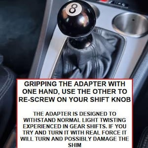 Może przedstawiać: Czarny gałka zmiany bieg&oacute;w z białą cyfrą 8, zamontowana w samochodzie. Tekst na zdjęciu brzmi: GRIPPING THE ADAPTER WITH ONE HAND, USE THE OTHER TO RE-SCREW ON YOUR SHIFT KNOB.