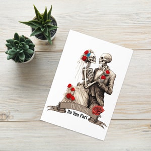 Op de afbeelding: Witte kaart met een skeletbruid en -bruidegom in trouwkleding, versierd met rode rozen. De tekst "Til Death Do You Part" staat op een banner. Twee kleine vetplanten in potten staan op de achtergrond.