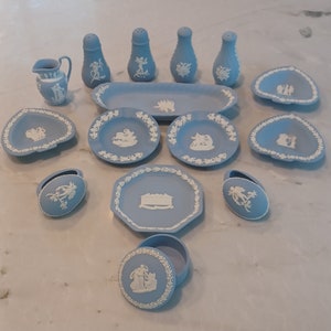 May include: A collection of blue and white ceramic dishes and boxes with various floral and figurative designs. The set includes a creamer, sugar bowl, salt and pepper shakers, and small decorative dishes.