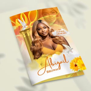 May include: A yellow and orange floral memorial card with a photo of a woman. The text "In Loving Memory" and "Abigail Brown" is printed on the card.