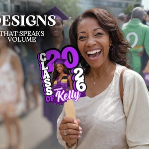 May include: A woman smiles while holding a graduation sign that says "Class of 2026" and "Congrats Kelly". The sign is purple and white with a photo of a graduate. The background includes other people.
