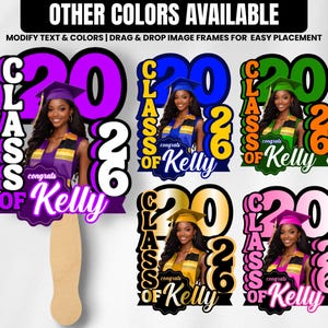 May include: Graduation photo booth props with the text "Class of 2026" and "Congrats Kelly." The props feature a photo of a woman in a graduation cap and gown. Available in purple, blue, green, gold, and pink.