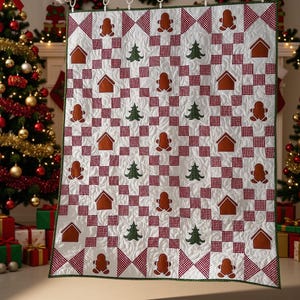 May include: A white quilt featuring a repeating pattern of brown gingerbread people, green pine trees, and brown house shapes, interspersed with red and white checkered squares. The quilt has a dark green border and quilted texture.