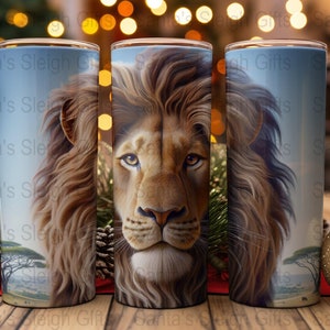 Op de afbeelding: Drie roestvrijstalen bekers met een leeuwenkopontwerp. De leeuw heeft een lichtbruine manen en een lichtbruin gezicht. De achtergrond is een lichtblauwe lucht met een savannelandschap.