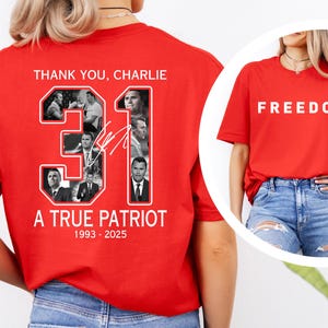 May include: Red t-shirt with the word "FREEDOM" in white block letters. Another red t-shirt features the text "THANK YOU, CHARLIE", the number "31", and the words "A TRUE PATRIOT 1993-2025" with a collage of images.