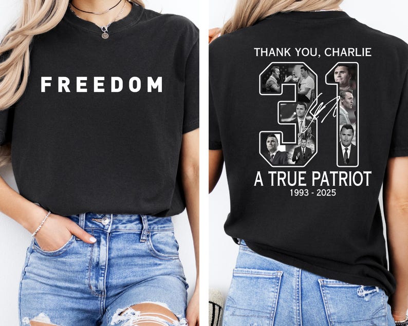 May include: Black t-shirt with the word "FREEDOM" in white block letters on the front. The back of the shirt features the text "THANK YOU, CHARLIE" above the number "31" with images and the text "A TRUE PATRIOT 1993-2025".