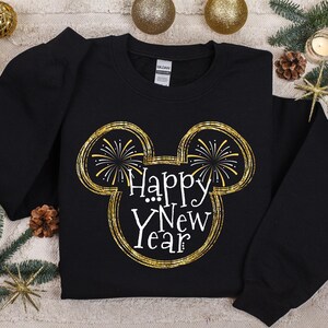 Pu&ograve; includere: Felpa nera con un design oro e bianco "Happy New Year". Il design presenta una forma ispirata a Mickey Mouse con fuochi d'artificio e testo. La felpa &egrave; uno stile girocollo.
