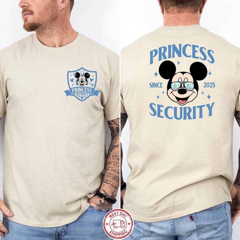May include: Beige t-shirt featuring a Mickey Mouse graphic with the text "PRINCESS SECURITY" in blue. The front of the shirt has a shield design with the same graphic and text. The back of the shirt has the text "PRINCESS SECURITY" with the Mickey Mouse graphic.
