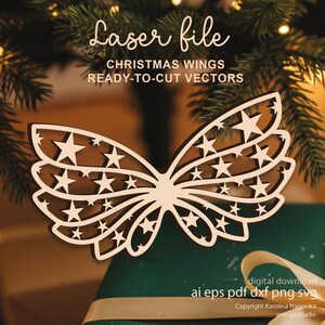 May include: A laser-cut wooden Christmas wing design with star cutouts. The image includes the text "Laser file," "CHRISTMAS WINGS," and "READY-TO-CUT VECTORS." The design is a digital download in various file formats.