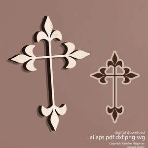 May include: Two decorative wooden crosses with ornate, stylized designs. One cross is larger, with a light wood color and dark shadow, while the other is smaller with a brown outline. The background is a muted brown.