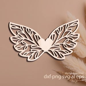 May include: A wooden cutout of stylized butterfly wings with a heart in the center. The wings feature intricate leaf and branch designs. The image includes the text "digital download dxf.png.svg.ai.eps".