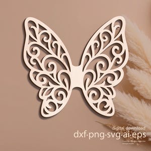 Può includere: Un ritaglio di legno a forma di farfalla con intricati motivi a spirale. Le ali simmetriche sono collegate al centro. Il testo "digital download dxf.png.svg.ai.eps" è incluso.