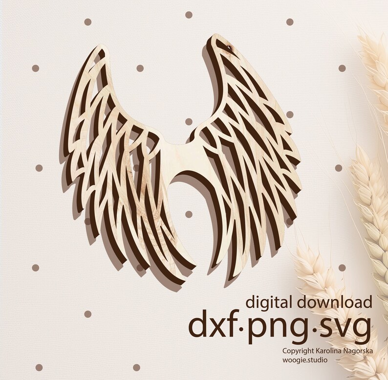 May include: A wooden cutout of angel wings with a detailed intricate design. The wings are light brown and have a natural wood grain. The image includes the text "digital download dxf.png.svg Copyright Karolina Nagorska woogie.studio".