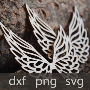May include: Two intricately cut wooden wings with a delicate, lacy design. The wings are light brown and have a natural wood finish. They are arranged in a symmetrical pattern, with the tips of the wings pointing upwards.