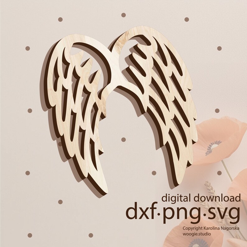 May include: A wooden cutout of angel wings in a light brown color. The wings are layered and have a delicate, intricate design. The image has a light brown background with small white dots.