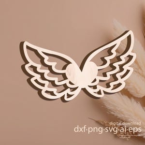 Könnte beinhalten: Holzausschnitt von Engelsflügeln mit einem Herz in der Mitte. Die Flügel sind hellbraun mit einem detaillierten, geschichteten Design. Das Bild enthält den Text "digital download dxf.png.svg.ai.eps".