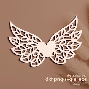 May include: A wooden angel wing design with a heart-shaped centre. The wings have a detailed, openwork pattern with leaf motifs. The text "digital download dxf.png.svg.ai.eps" is displayed at the bottom of the image.