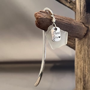 May include: Silver bookmark with a white sea glass charm that says "Thank You" with a small heart.