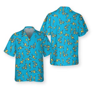 May include: Two short-sleeved button-down shirts. The shirts are light blue with a yellow flame pattern. One shirt is displayed from the front, and the other from the back. The collar of the front shirt has the text "HYPERWAVE".