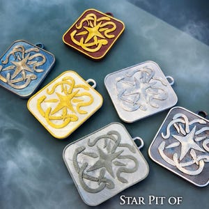Puede incluir: Conjunto de colgantes cuadrados con dise&ntilde;o de estrella y serpiente. Los colgantes est&aacute;n disponibles en varios colores, como azul, dorado, plateado y burdeos. Se puede leer el texto "STAR PIT OF SNAKES DESIGN". Cada colgante tiene un peque&ntilde;o lazo.