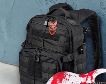 Llavero/etiqueta para bolso con máscara de calavera inspirada en la campaña "Slaughter to Prevail" de Savage Fan Gear.