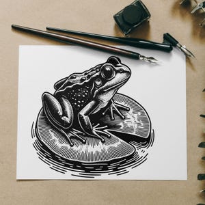 Puede incluir: Una ilustración en blanco y negro de una rana sentada en un nenúfar. La rana está detallada con manchas y tiene un ojo grande. El nenúfar es texturizado y tiene una forma curva.