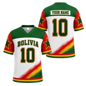 May include: A V-neck sports jersey featuring a white mesh body with green shoulders and red sleeves. The front displays the text BOLIVIA and the number 10 in green with yellow and red outlines. A diagonal brushstroke pattern in red and yellow appears.