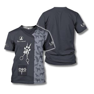 以下が含まれることがあります： 犬のグルーミングをテーマにしたVネックデザインの濃いグレーのTシャツ。前面には足跡、ハサミ、テキスト「DOG GROOMER」が表示されています。右側には犬のシルエットのパターンがあります。背面は無地の濃いグレーです。