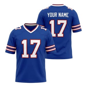 May include: Two blue football jerseys with the number 17 in white and red. The jerseys have white and red stripes on the sleeves and the text "YOUR NAME" on the back.