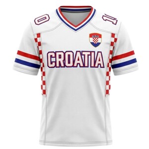 May include: White Croatia football shirt with red, white, and blue detailing. The shirt displays the word "CROATIA" across the chest, a Croatian coat of arms, and the numbers "0" and "1" on the shoulders.
