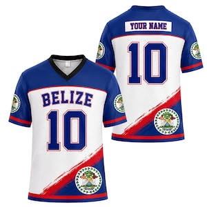 May include: A blue and white V-neck jersey featuring the text BELIZE and the number 10 on the front, with the Belize coat of arms and a red diagonal stripe. The back displays the text YOUR NAME and the number 10 with matching design elements.
