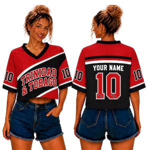 May include: A red and black cropped V-neck jersey featuring the text Trinidad & Tobago on the front, the number 10 on the sleeves, and the text Your Name with the number 10 on the back, paired with blue denim shorts.