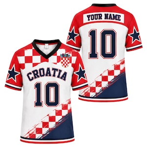 May include: A white, red, and navy blue jersey featuring a V-neck collar, the text CROATIA, the number 10, and a checkerboard pattern. The back displays the text YOUR NAME and the number 10. Both sides feature navy blue stars on the sleeves.