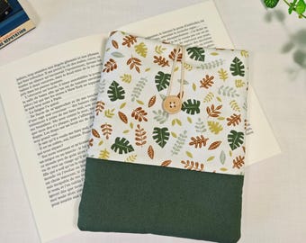 May include: A rectangular fabric pouch featuring a white upper section with a repeating pattern of green and brown leaves and a solid dark green lower section. The pouch is secured with a light brown wooden button and a thin elastic loop closure.
