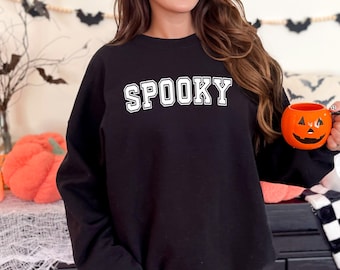 May include: Black sweatshirt with white text that says "SPOOKY" in a varsity style font.