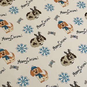 May include: White wrapping paper with a repeating pattern of cartoon dogs wearing hats and scarves, snowflakes, and dog bones. The words "Merry Christmas!" are written in black cursive throughout the design.