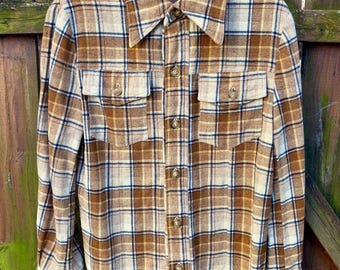May include: A brown and white plaid flannel shirt with a button-up front and long sleeves. The shirt has two flap pockets on the chest.