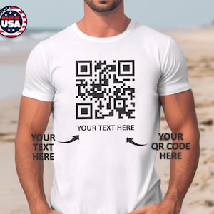 May include: White t-shirt featuring a black QR code design. The text "YOUR TEXT HERE" is printed below the QR code. Arrows point to the left and right of the text, with the words "YOUR TEXT HERE" and "YOUR QR CODE HERE" printed next to the arrows.