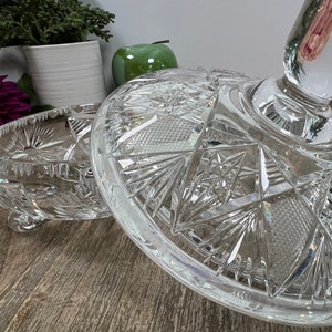 Puede incluir: Un soporte para tartas de cristal transparente con un dise&ntilde;o decorativo de cristal tallado. El soporte tiene una base redonda y un poste central cil&iacute;ndrico.