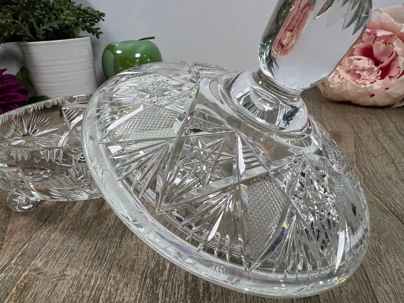 Puede incluir: Un soporte para tartas de cristal transparente con un dise&ntilde;o decorativo de cristal tallado. El soporte tiene una base redonda y un poste central cil&iacute;ndrico.