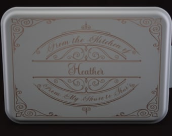 May include: A white cake pan with a gold design and the text "From the Kitchen of Heather From My House to Yours".