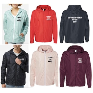 May include: Six hooded windbreakers in different colors, including light blue, red, navy blue, black, pink, and burgundy. Each jacket has a zipper closure and a drawstring hood. The jackets have text on the front, including "LOGO PIC TEXT" and "CUSTOM TEXT LOGO PIC".